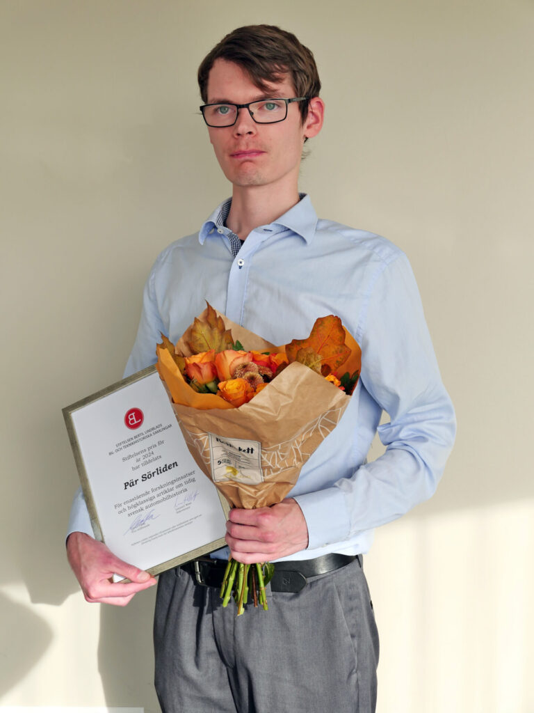 Pär Sörliden med diplom och blomsterbukett i samband med att han fick Bertil Lindblads stiftelses stipendium för 2024.