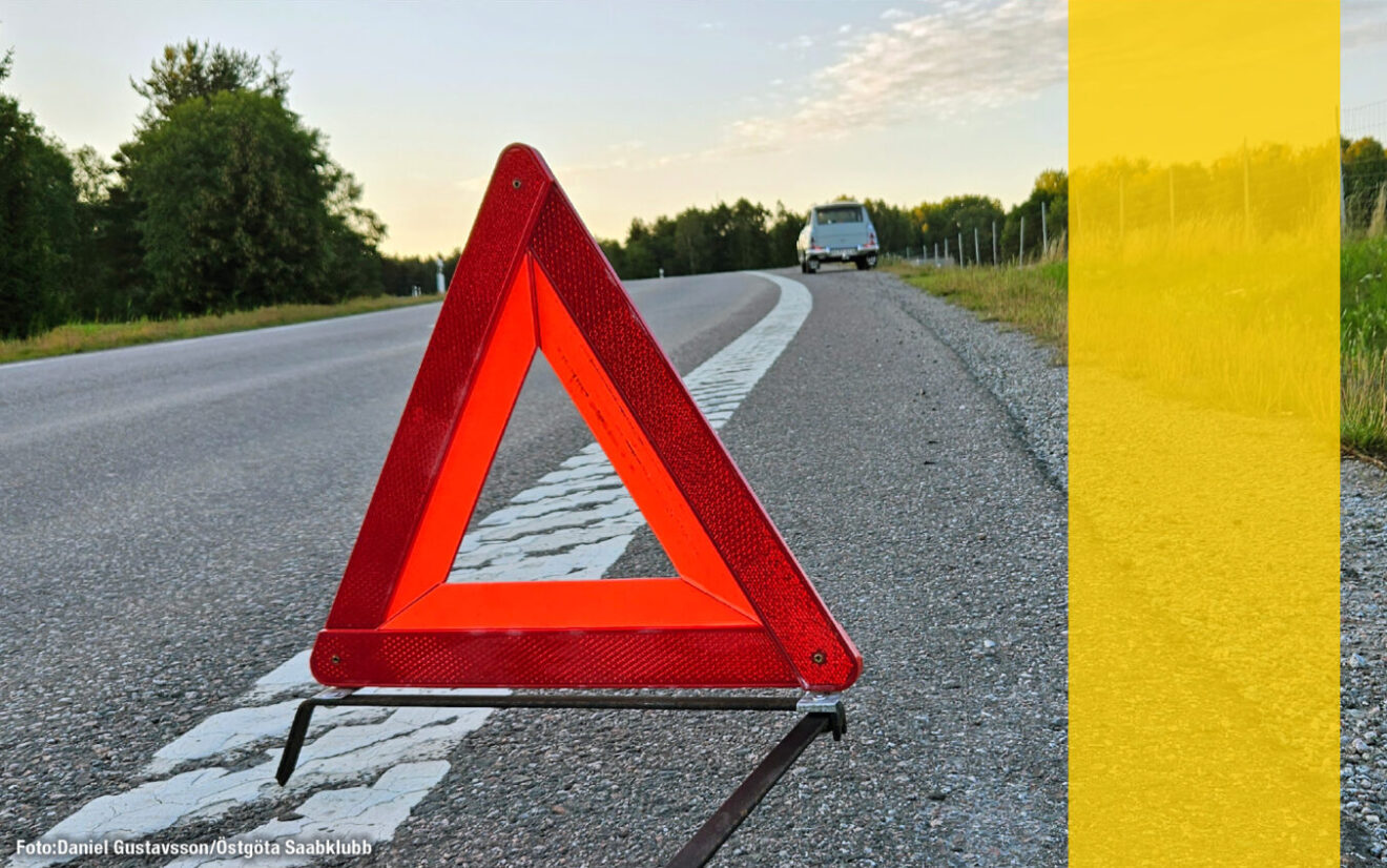 Gammal Saab i väggrenen med en varningstriangel framför.